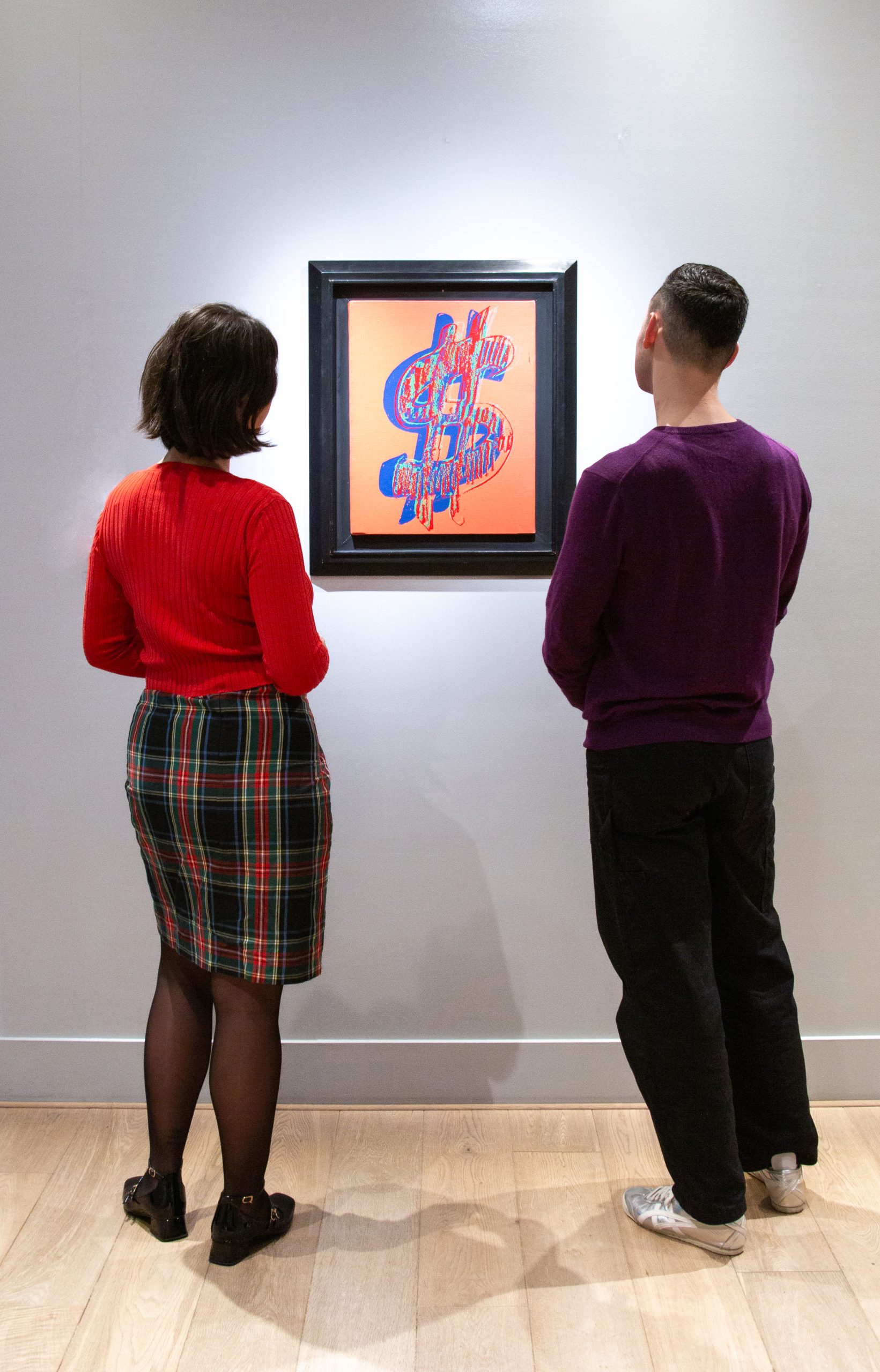Visitors viewing Andy Warhol's Dollar Sign artwork at Moco Museum Amsterdam