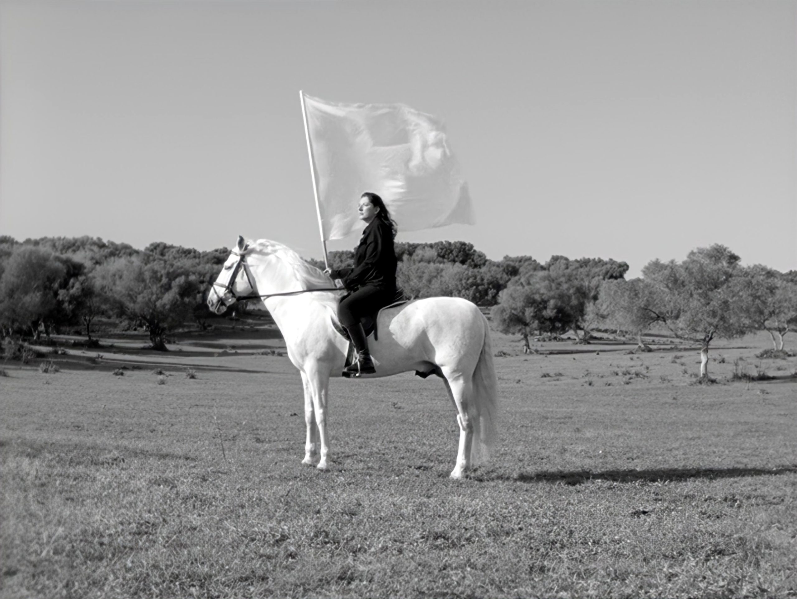 Marina Abramovic on a white horse holding a flag in The Hero, exhibited at Moco Museum Amsterdam.