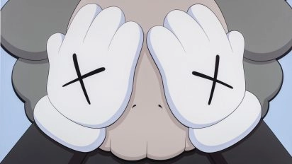 Close-up of KAWS sculpture "Companion (Passing Thought)" with hands covering face at Moco Museum Barcelona